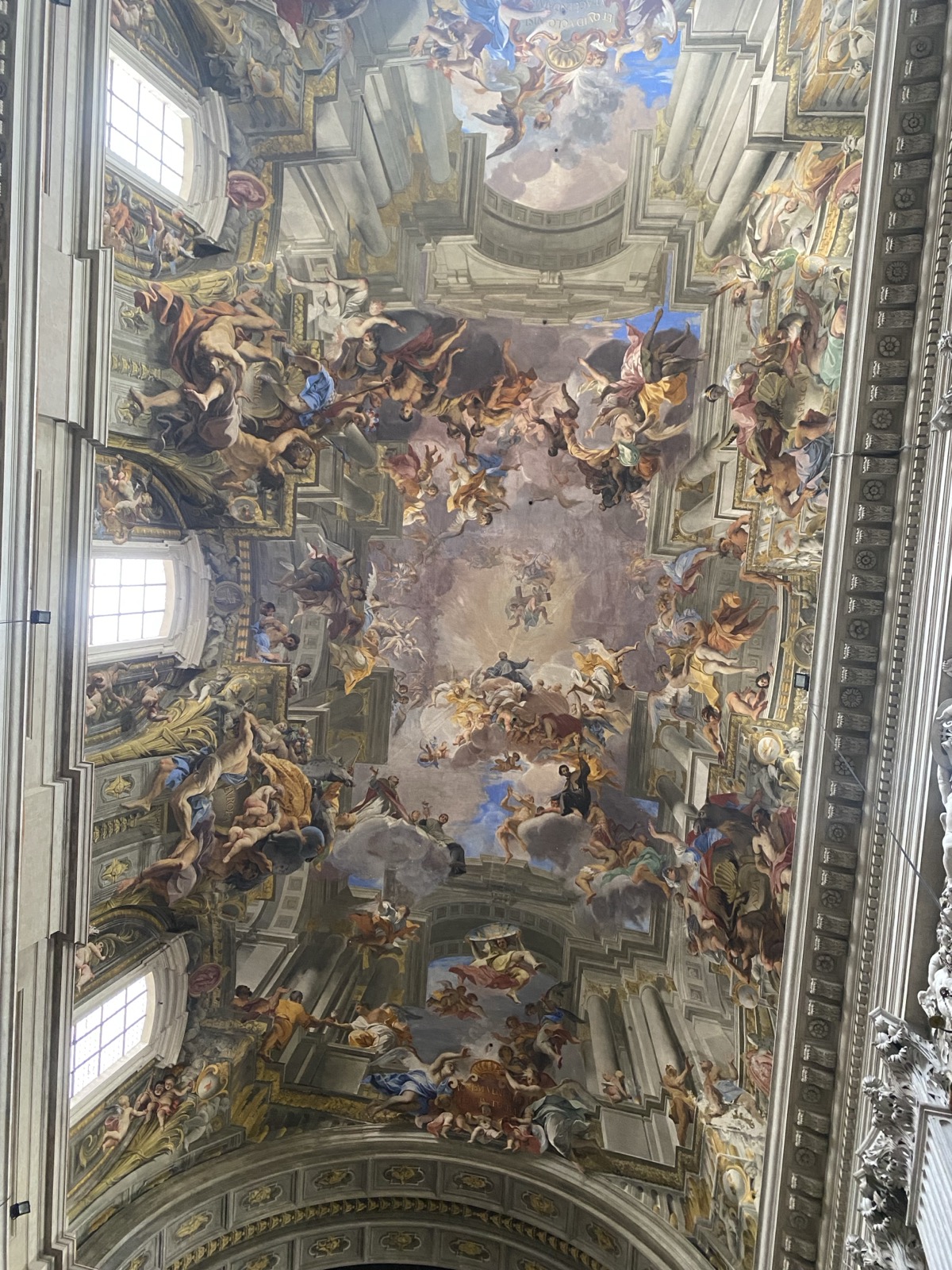 Ornate baroque church ceiling in Rome — gilded frescoes of saints and angels